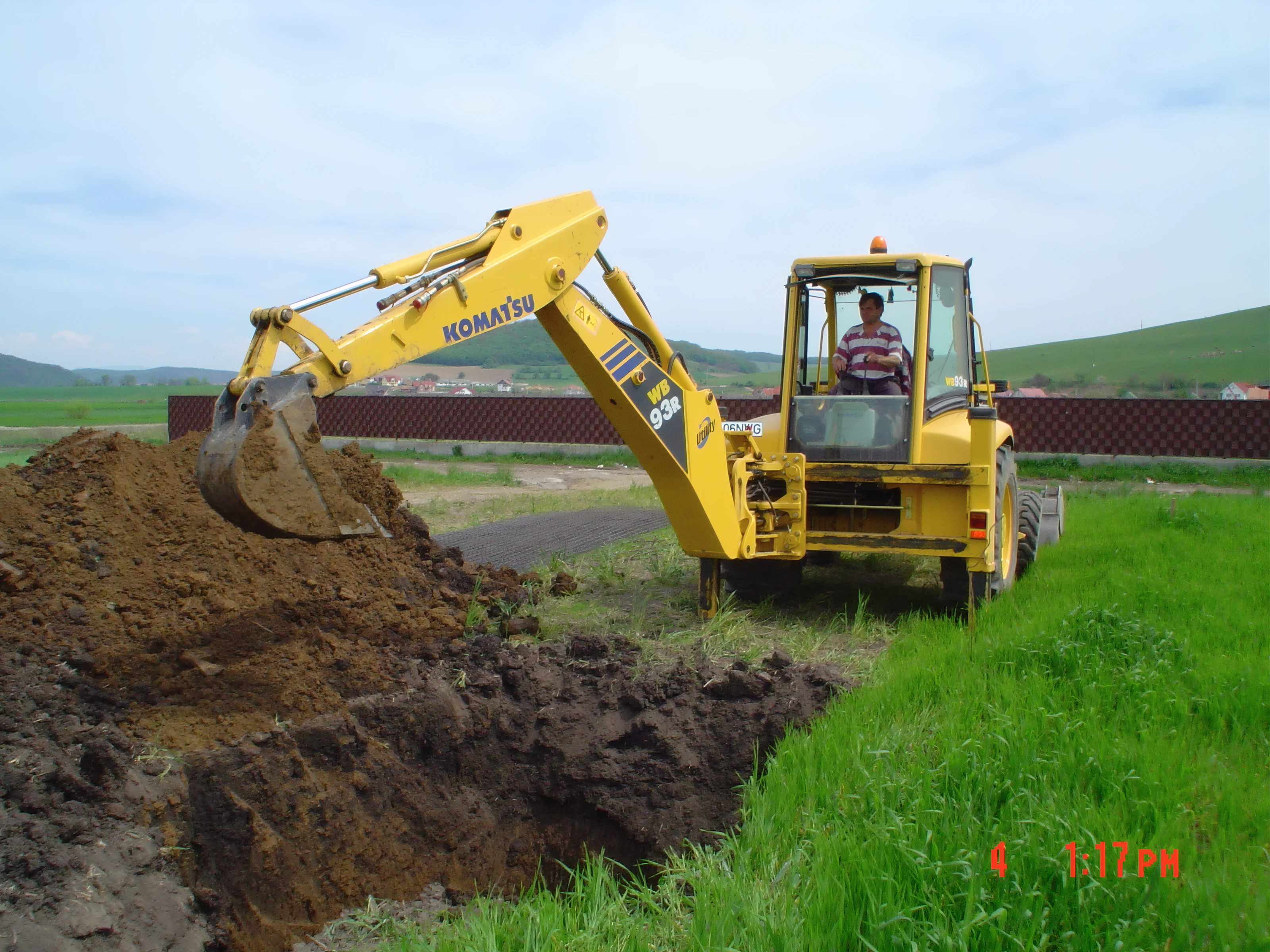 Buldoexcavator Komatsu Modinvest executând lucrări de pământ în 2004